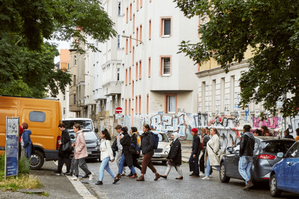 Das Foto zeigt eine Gruppe Menschen, die eine Straße passiert.